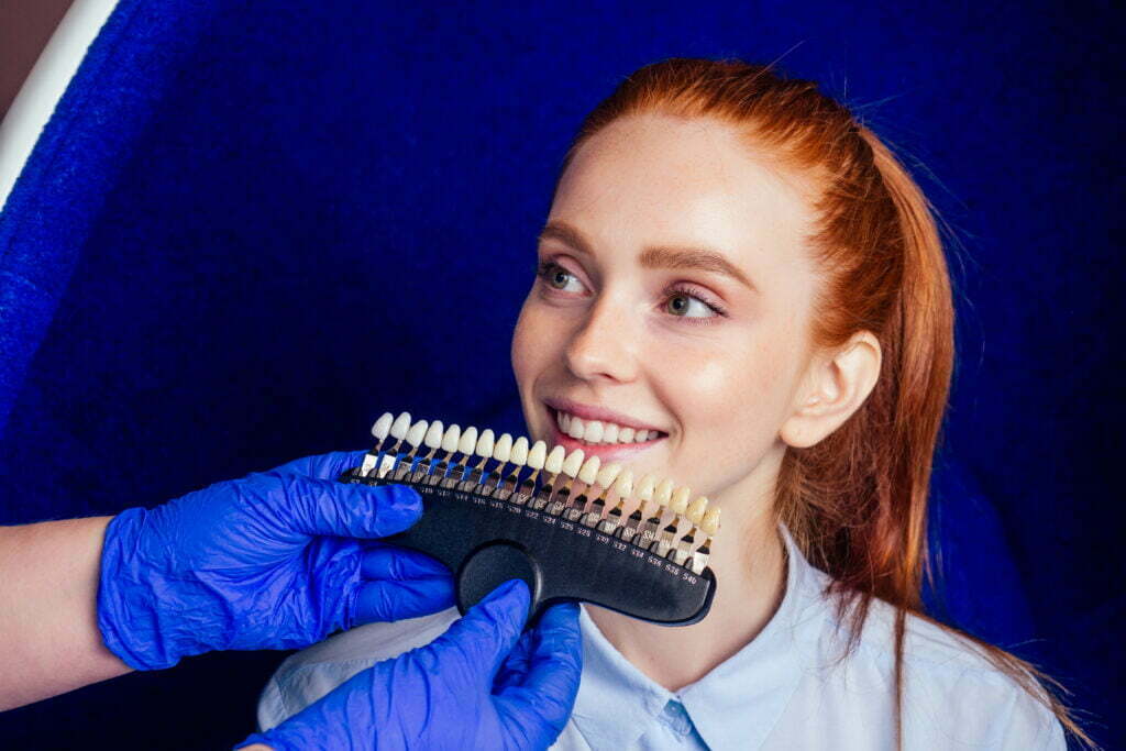 dentist works on tooth crown in dental laboratory ultraviolet painting teeth